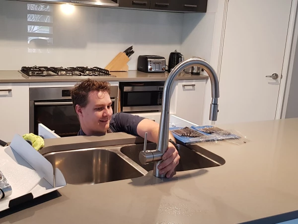 Michael fixing mixer taps in the kitchen