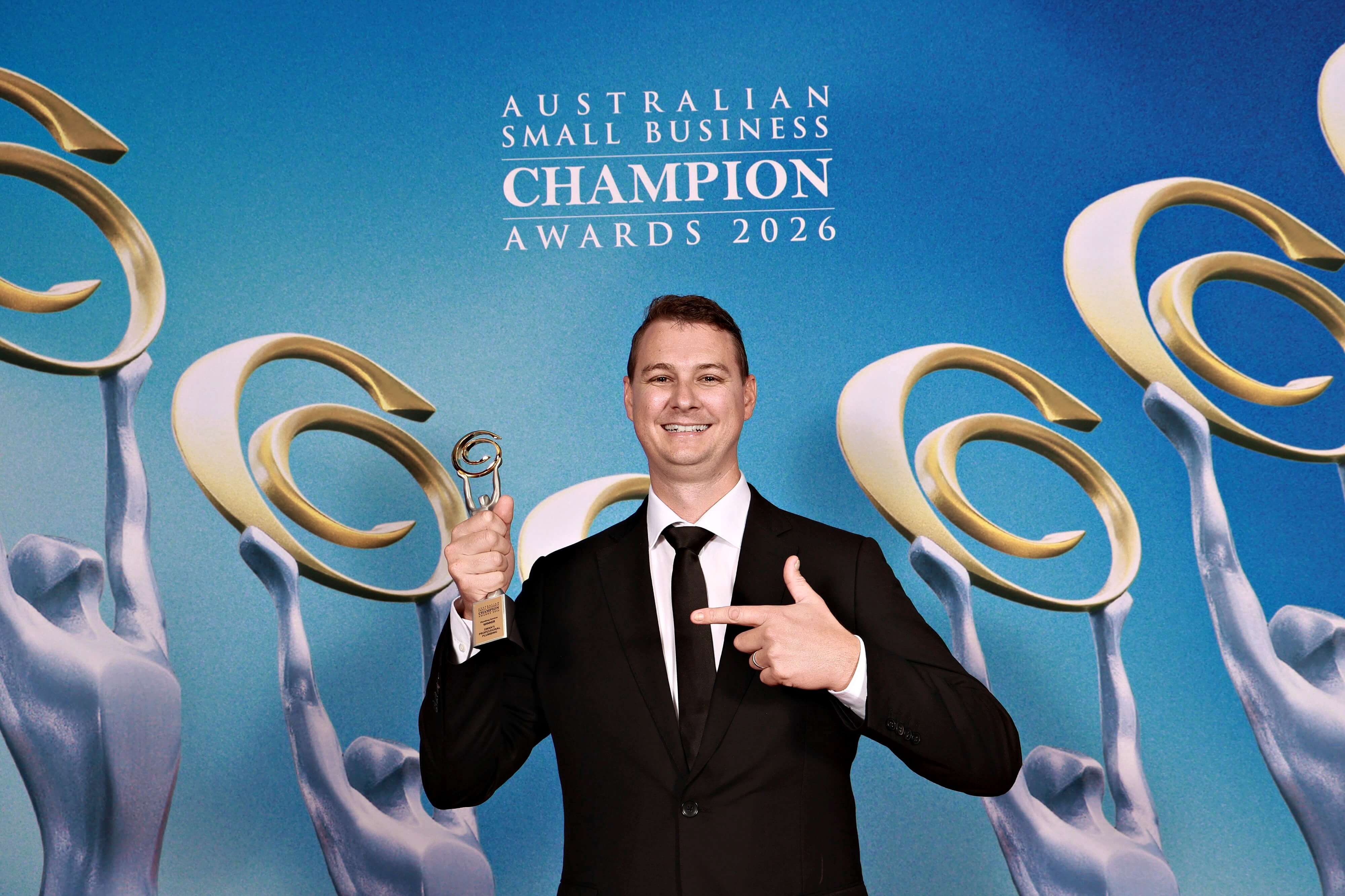 Michael Swan holding his small business champion award trophy 