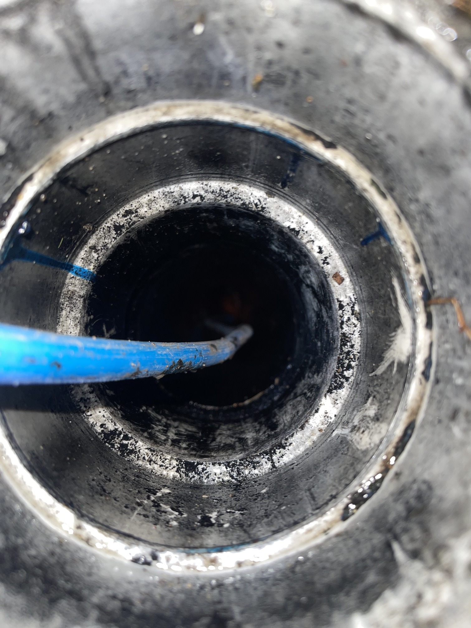 CCTV drain camera cable inserted into a main sewer pipe