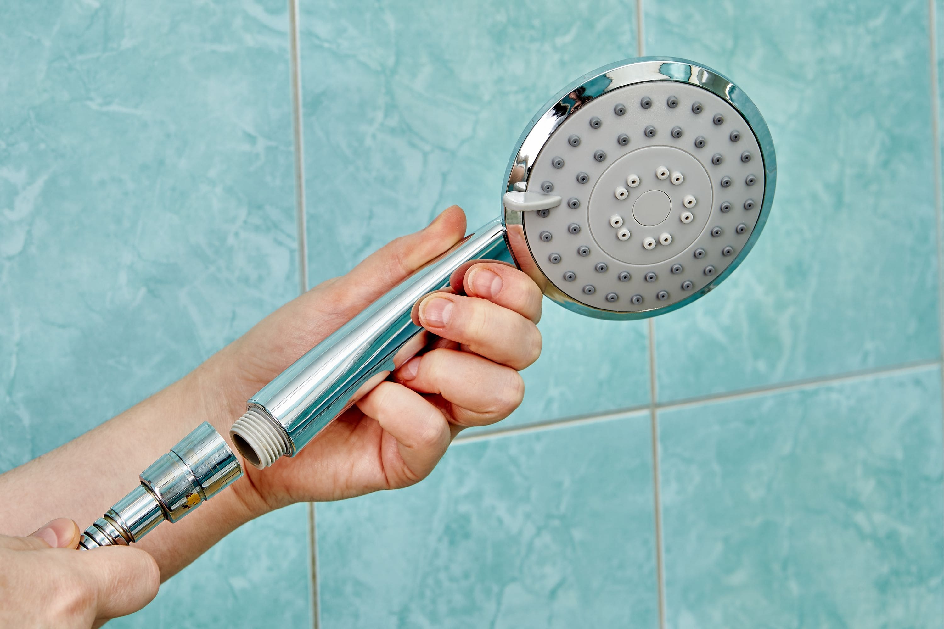 A person installing a water efficient showerhead