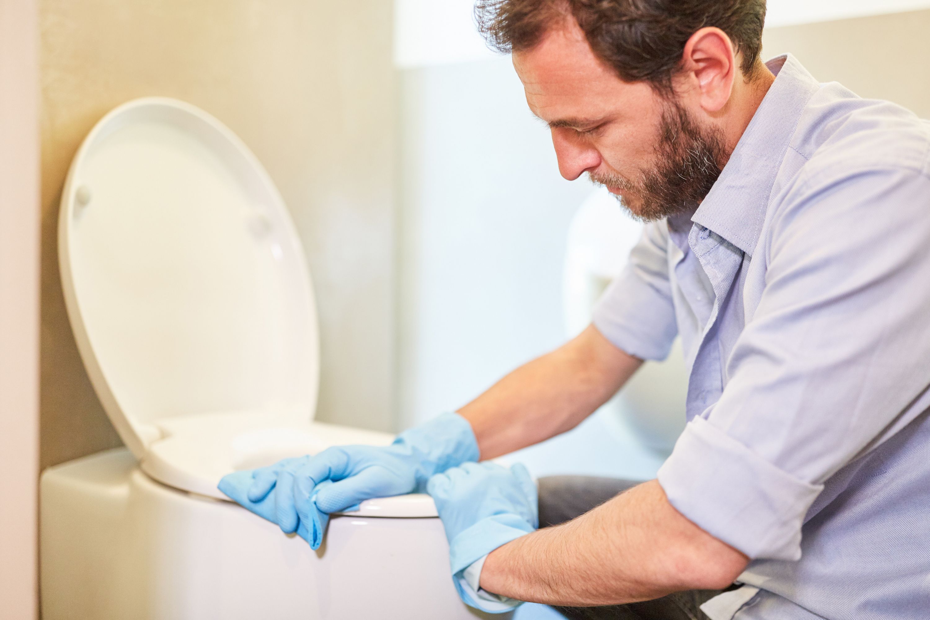 A person manually clearing their toilet